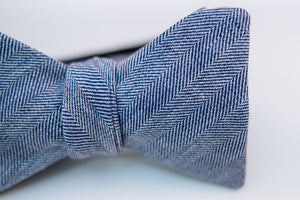 A two-toned herringbone linen bow tie with blue and white hues on this mid-weight bow tie.   Imported from Ireland.  100% Linen  Height: 3" x Width: 4.25" x Knot Size: .75 (Approx.)  Dry Clean Only