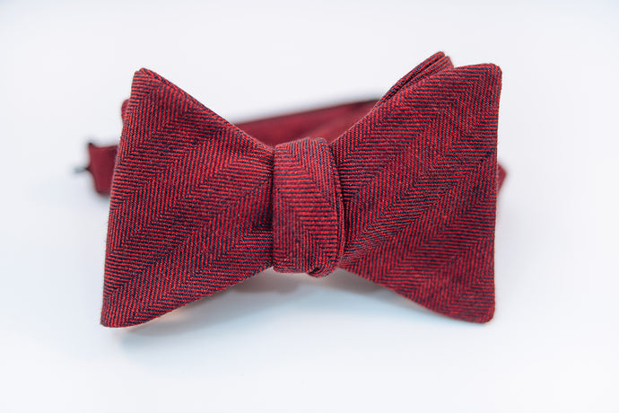 A two-toned herringbone linen bow tie with red and black hues on this mid-weight bow tie.   Imported from Ireland.  100% Linen  Height: 3