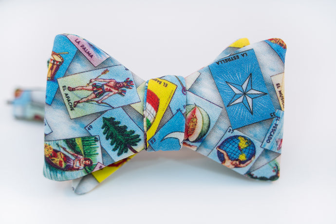 Loteria themed bow tie with dozens of possibilities of what you might get when you place your order. A lightweight cotton bow tie hoast the Loteria board game with blue/white hues as its background.   No Loteria pattern placement is guaranteed as each bow tie will vary slightly.   Height: 3