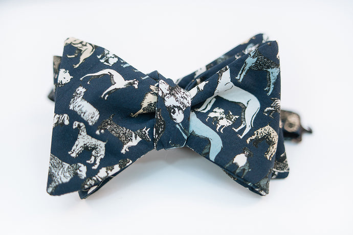 Calling all dog lovers, this lightweight cotton poplin bow tie with dog print on a navy background is the ultimate way to show your love for your favorite pup.   Height: 3