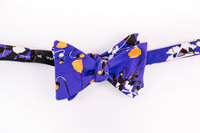 Liberty Of London Cotton Bow Tie With A Poppy Floral Design. A Orange Poppy dances on a solid blue background and abstract black and white floral patterns to tone down this traditional butterfly design. 
